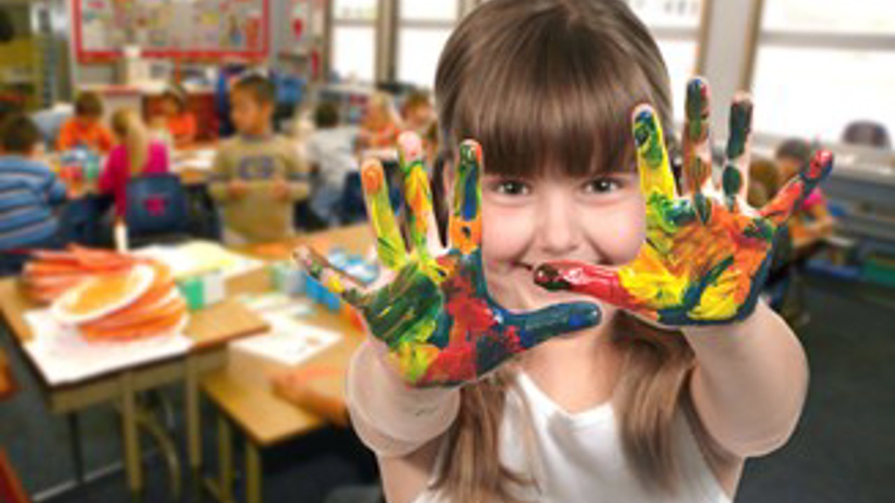 School Age Child Painting With Her Hands In Class